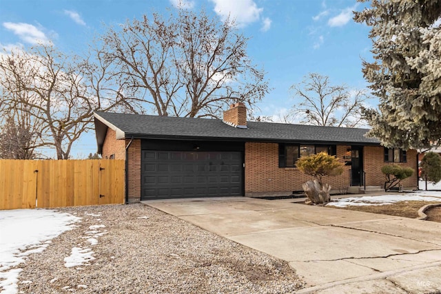 view of front of property featuring brick siding, a chimney, concrete driveway, and a garage