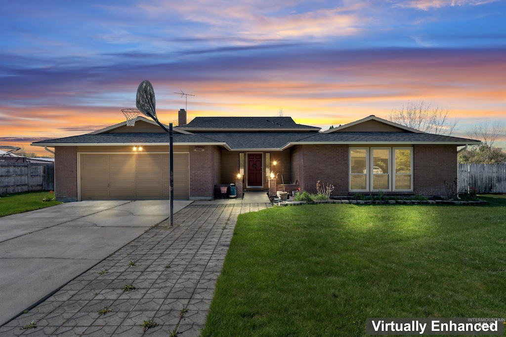 11185 W Hummingbird Dr, Boise, ID 83709 - view of front of home featuring fence, an attached garage, driveway, brick siding, and a front yard