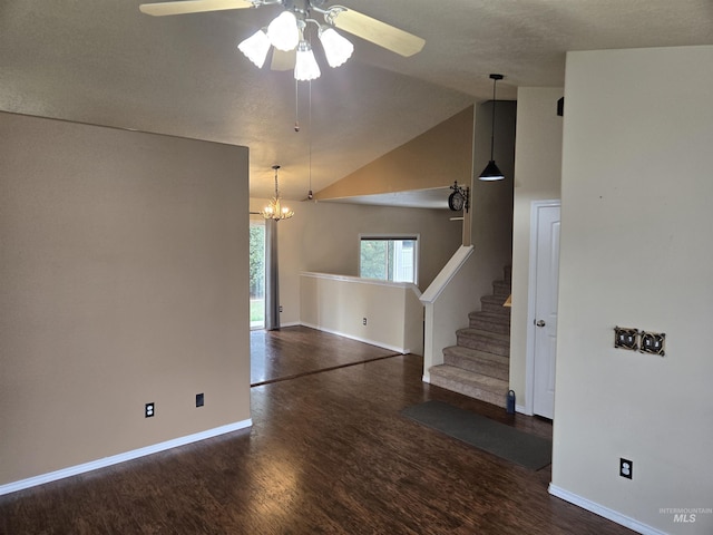 interior space with ceiling fan with notable chandelier, dark wood-type flooring, and lofted ceiling