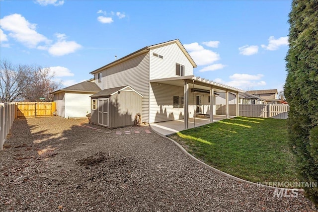 rear view of house featuring a lawn, a shed, and a patio