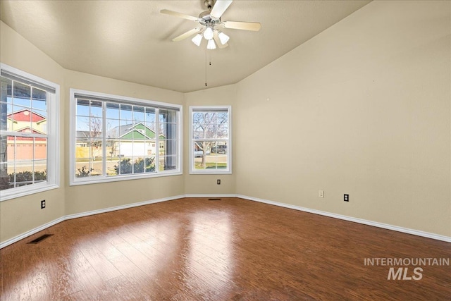 spare room with ceiling fan, vaulted ceiling, and hardwood / wood-style flooring