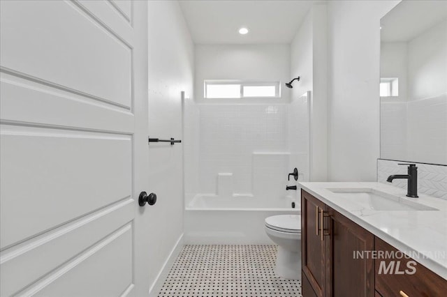 bathroom featuring  shower combination, vanity, toilet, and tile patterned floors