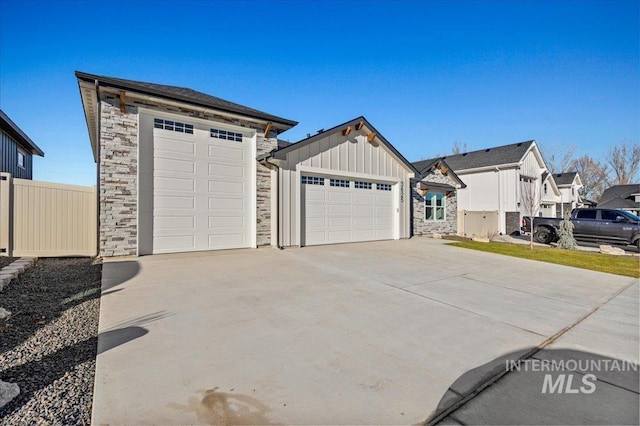 garage featuring driveway and fence