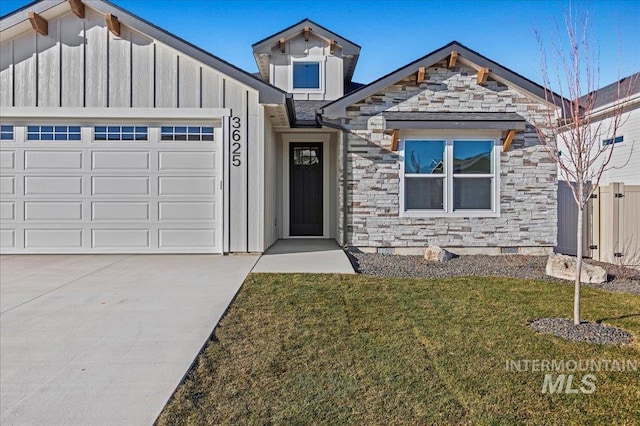 view of front of house with stone siding, a front lawn, board and batten siding, and an attached garage