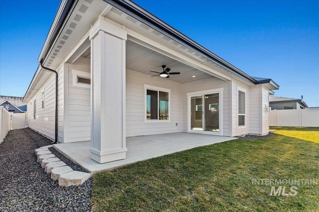 rear view of property with a patio area, ceiling fan, a lawn, and fence