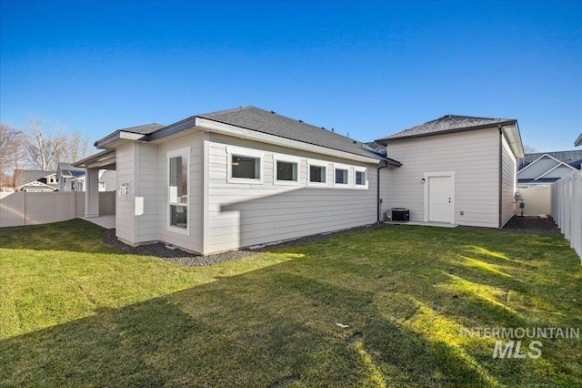 back of property featuring cooling unit, a fenced backyard, and a lawn