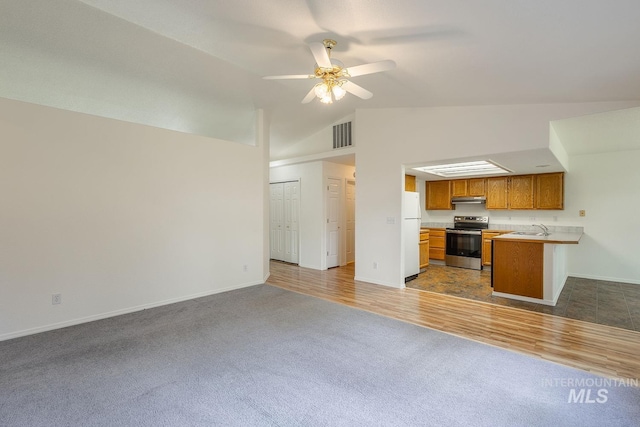 5426 W Samara Ct, Boise, ID 83703 - kitchen with stainless steel electric stove, under cabinet range hood, dark colored carpet, open floor plan, and freestanding refrigerator