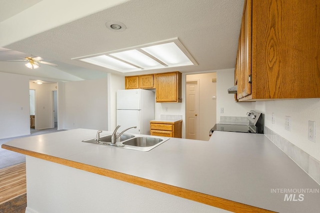5426 W Samara Ct, Boise, ID 83703 - kitchen featuring freestanding refrigerator, range with electric stovetop, a peninsula, ceiling fan, and brown cabinets