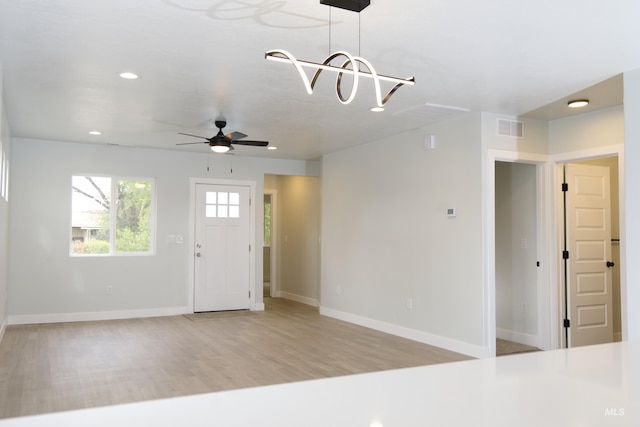602 E Freeport St, Caldwell, ID 83605 - unfurnished living room featuring baseboards, a chandelier, ceiling fan, recessed lighting, and light wood-style floors