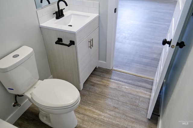 602 E Freeport St, Caldwell, ID 83605 - bathroom featuring toilet, wood finished floors, vanity, and tasteful backsplash