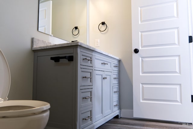 602 E Freeport St, Caldwell, ID 83605 - half bathroom with wood finished floors, vanity, toilet, and baseboards