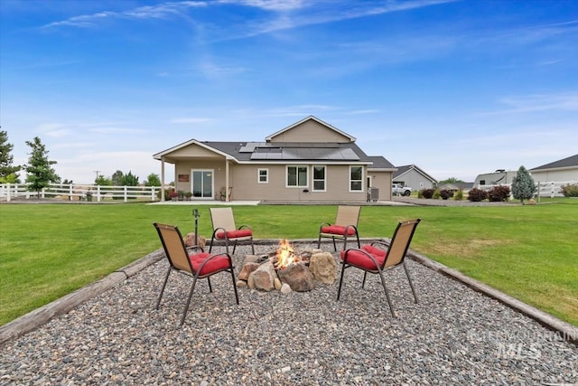 27482 Warren Ln, Wilder, ID 83676 - back of property with a fire pit, solar panels, and a patio area
