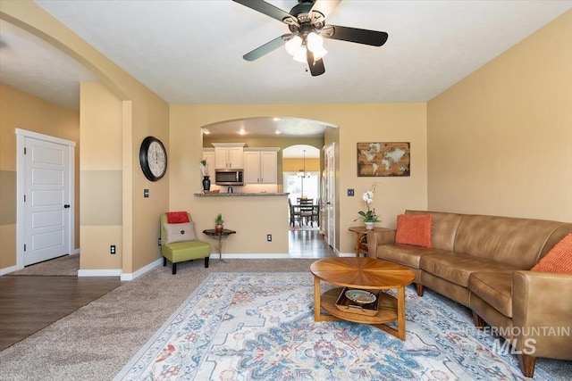 27482 Warren Ln, Wilder, ID 83676 - living room with arched walkways, carpet, and a ceiling fan
