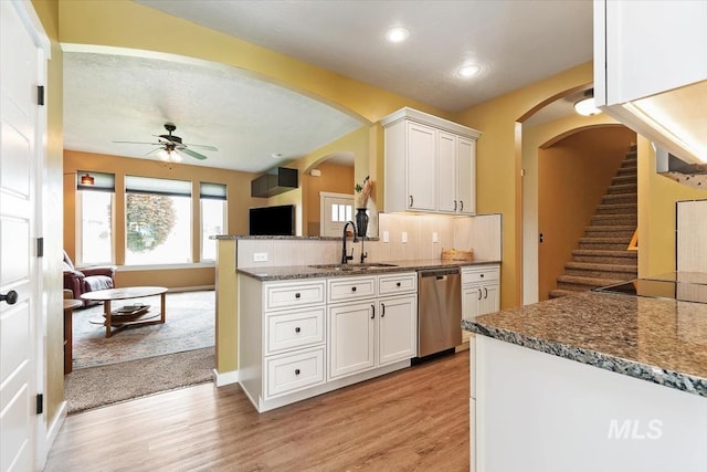 27482 Warren Ln, Wilder, ID 83676 - kitchen with stainless steel dishwasher, arched walkways, light wood finished floors, ceiling fan, and white cabinets