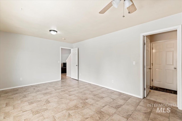 unfurnished room featuring a ceiling fan and baseboards