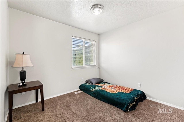 bedroom with baseboards, visible vents, a textured ceiling, and carpet