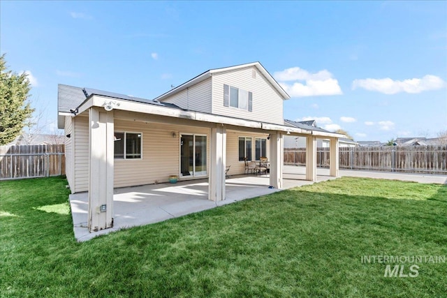 back of property featuring a patio area, a yard, and a fenced backyard