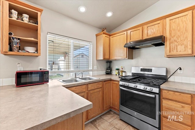 kitchen with stainless steel range with gas stovetop, a sink, vaulted ceiling, light countertops, and under cabinet range hood