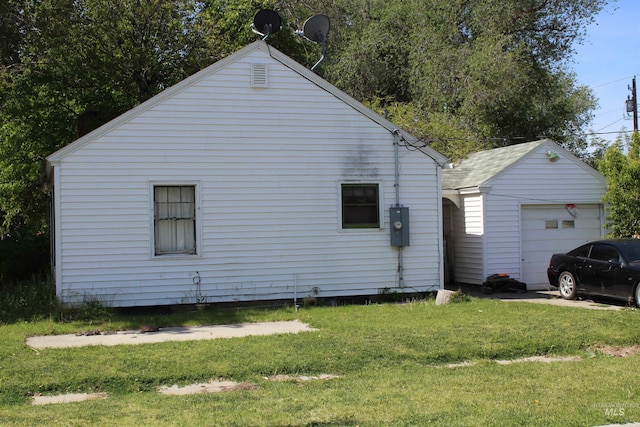 view of front of home featuring a front lawn, a garage, and an outdoor structure