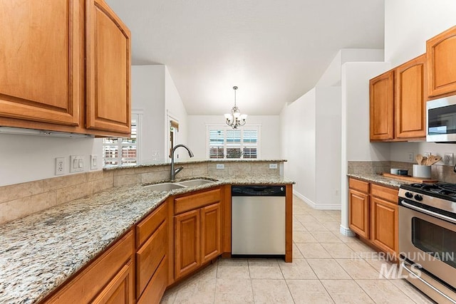 1730 W Glade Creek St, Meridian, ID 83646 - kitchen with stainless steel appliances, vaulted ceiling, a chandelier, light stone countertops, and brown cabinets