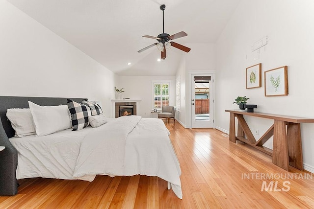 1730 W Glade Creek St, Meridian, ID 83646 - bedroom with lofted ceiling, access to exterior, light wood-type flooring, a glass covered fireplace, and a ceiling fan