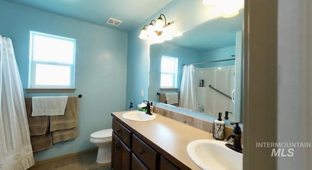 full bathroom with toilet, double vanity, curtained shower, tile patterned flooring, and baseboards
