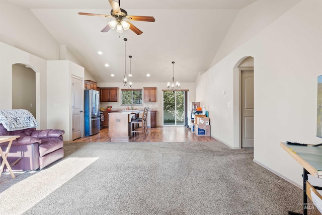 living area with light carpet, arched walkways, recessed lighting, a ceiling fan, and a chandelier