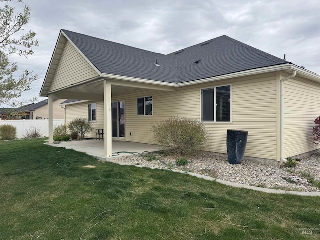 back of property with a patio area and roof with shingles