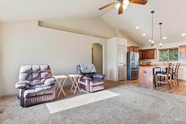 living room with arched walkways, vaulted ceiling, light carpet, a ceiling fan, and recessed lighting