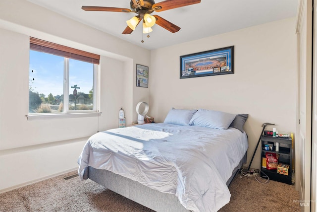 carpeted bedroom with a ceiling fan and baseboards