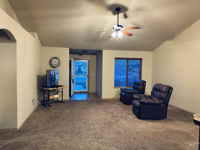carpeted living area featuring a ceiling fan, lofted ceiling, and baseboards