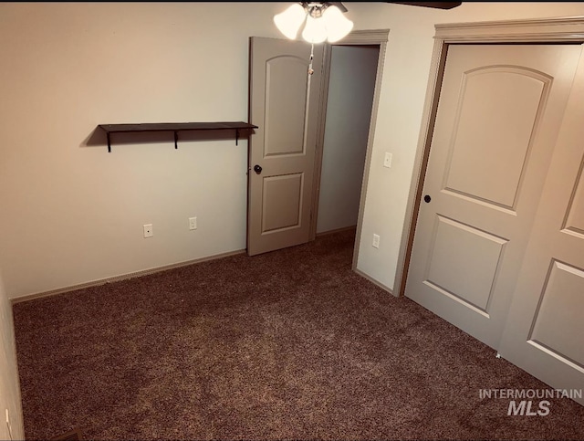carpeted empty room featuring ceiling fan and baseboards