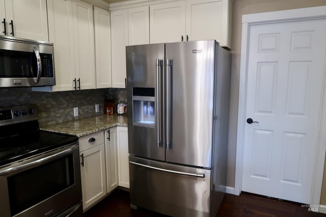 kitchen with decorative backsplash, light stone counters, white cabinetry, and appliances with stainless steel finishes