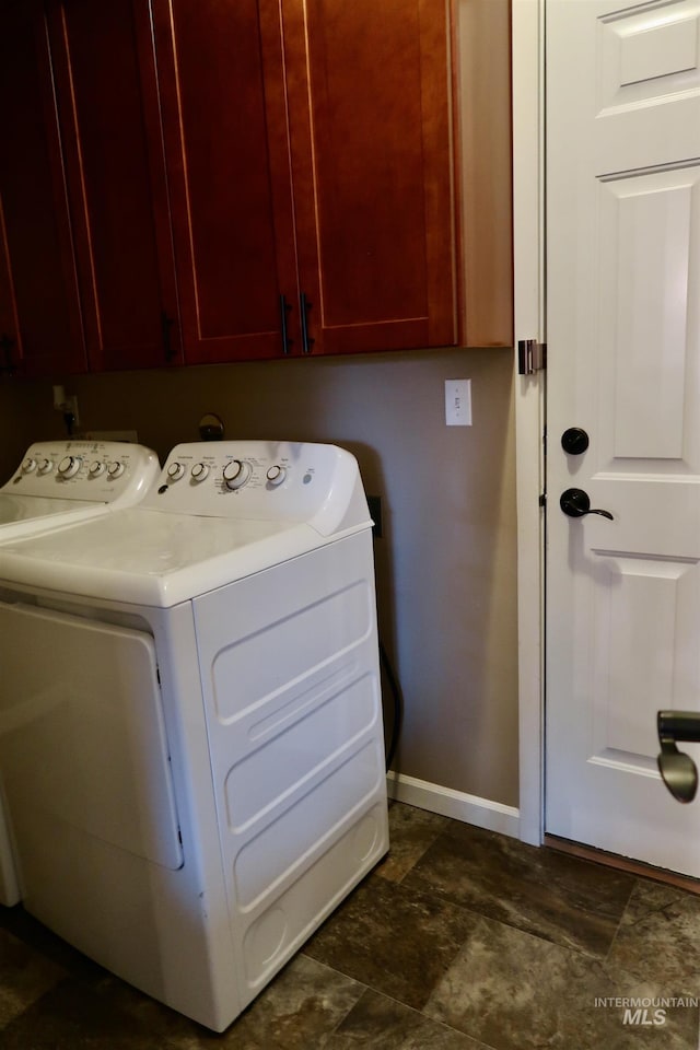 clothes washing area featuring cabinets and washer and dryer