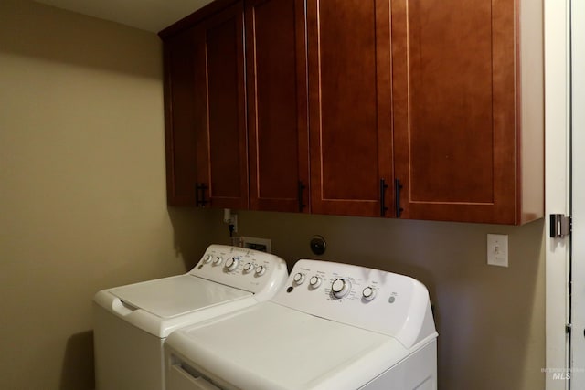 laundry room with washer and dryer and cabinets