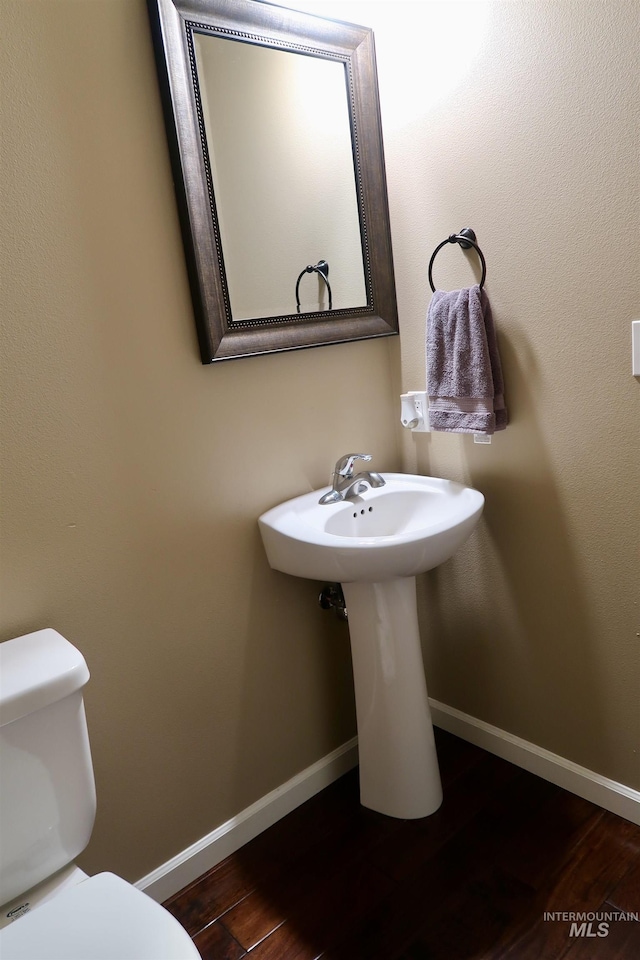 bathroom featuring hardwood / wood-style floors and toilet