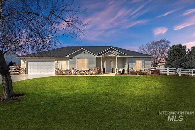 ranch-style home with an attached garage, driveway, fence, and a front yard