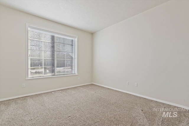 unfurnished room featuring baseboards and carpet flooring