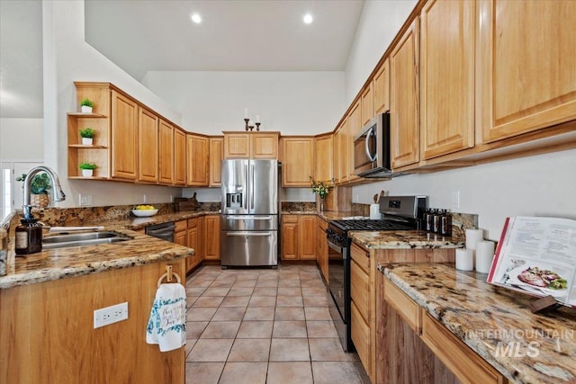 kitchen featuring light stone countertops, appliances with stainless steel finishes, open shelves, and a sink