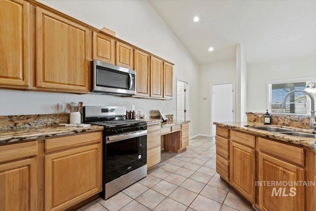 kitchen featuring light stone counters, light tile patterned flooring, stainless steel appliances, a sink, and recessed lighting