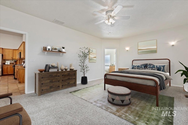 bedroom with a textured ceiling, connected bathroom, light colored carpet, visible vents, and freestanding refrigerator