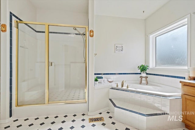 bathroom featuring a stall shower and a garden tub