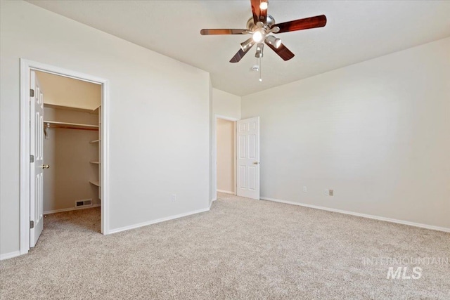 unfurnished bedroom with baseboards, visible vents, ceiling fan, a spacious closet, and carpet floors