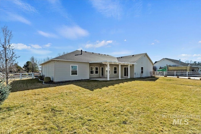 rear view of house with a patio area, a fenced backyard, and a yard