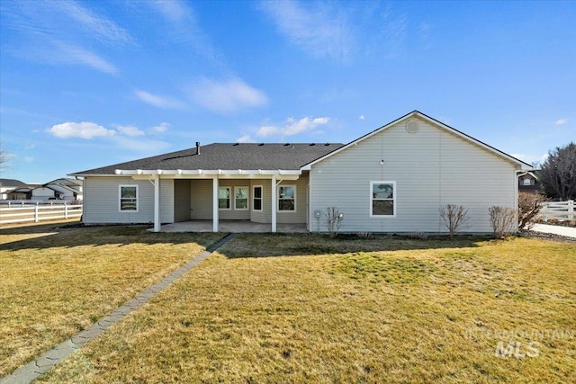 rear view of house with a patio area, fence, and a yard