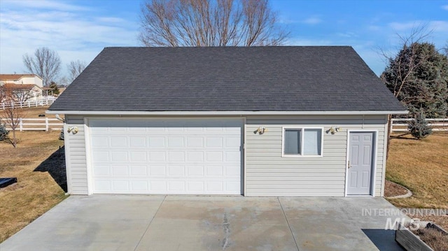 detached garage featuring fence