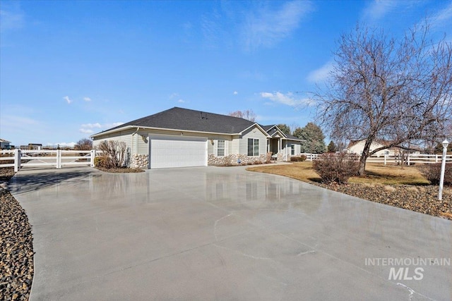 ranch-style home featuring an attached garage, fence, and concrete driveway