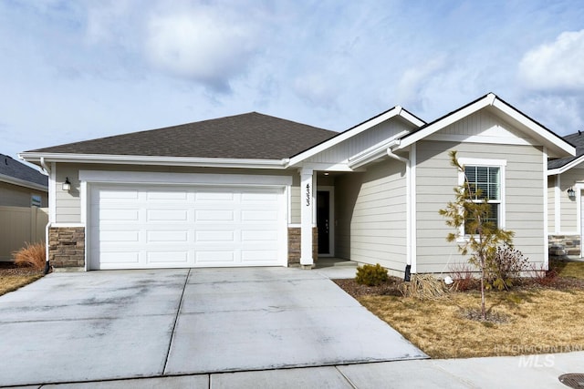 ranch-style house with a shingled roof, stone siding, driveway, and an attached garage