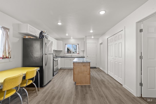 kitchen featuring white cabinetry, light wood-type flooring, and appliances with stainless steel finishes