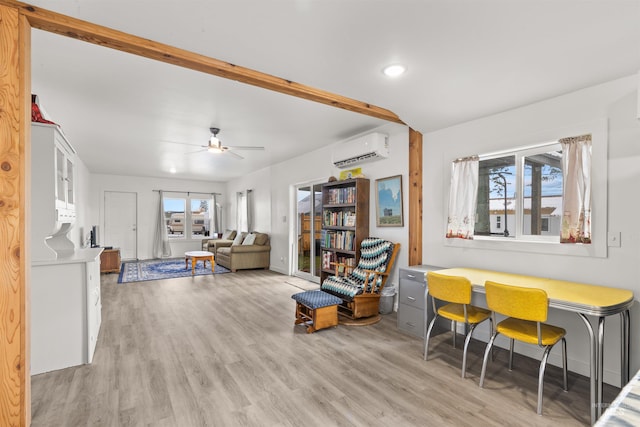 interior space featuring light hardwood / wood-style flooring, a wall unit AC, and ceiling fan